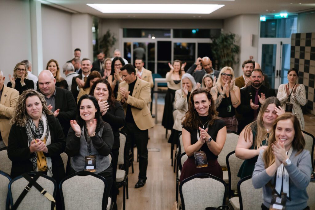 Participantes de um evento empresarial reunidos para uma fotografia de grupo.