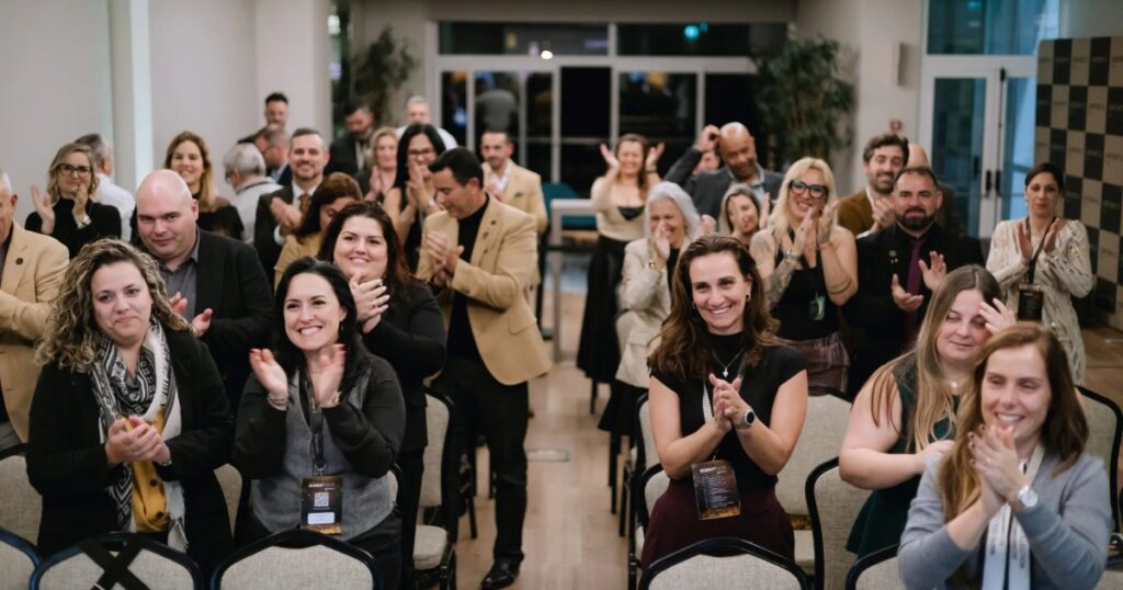 Plateia de um congresso a aplaudir, fotografada por Raiza Barbozza em Lisboa.